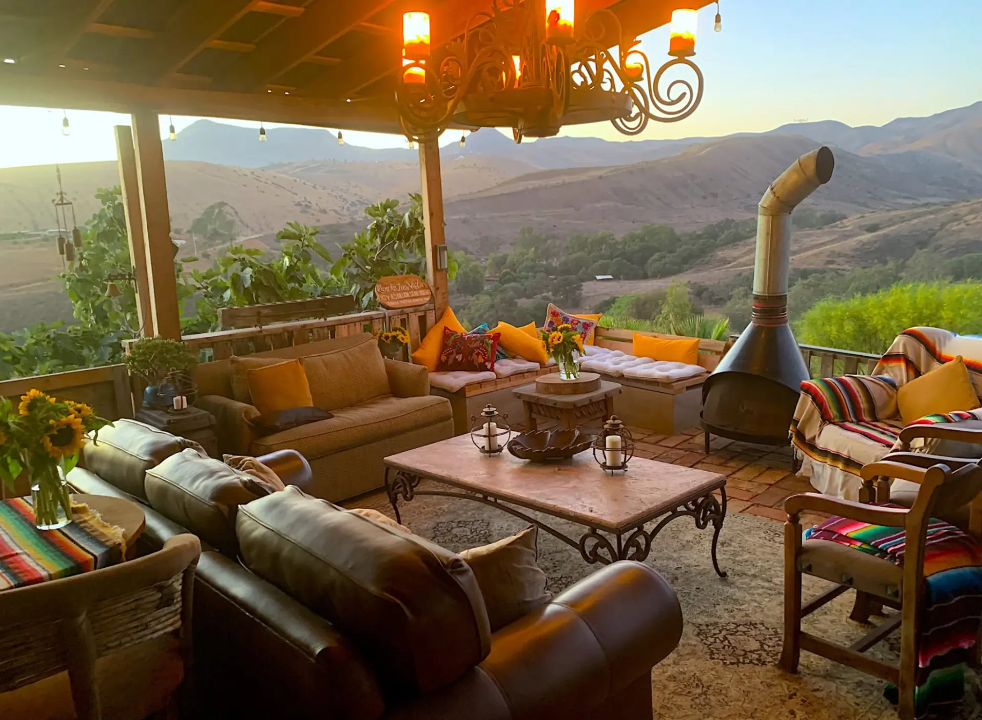 Sala de estar al aire libre de Three Vistas Ranch con vista a la montaña al atardecer